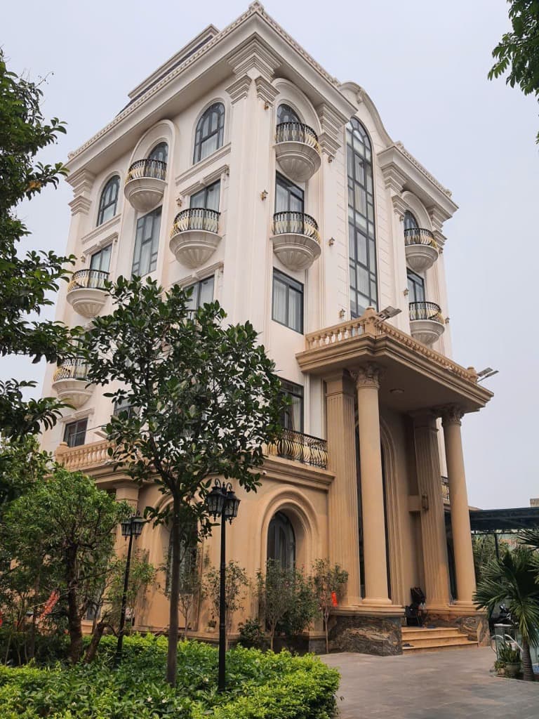 Thi Công Ngoại Thất & Dàn Nóng Biệt Thự Tân Cổ Điển 3 Tầng Dùng Daikin VRV H - Toàn cảnh dự án biệt thự 3 tầng xây thô đang được Kỹ sư Hanotech bắc giàn giáo thi công đi đường ống đồng âm tường và vị trí đặt dàn nóng trung tâm